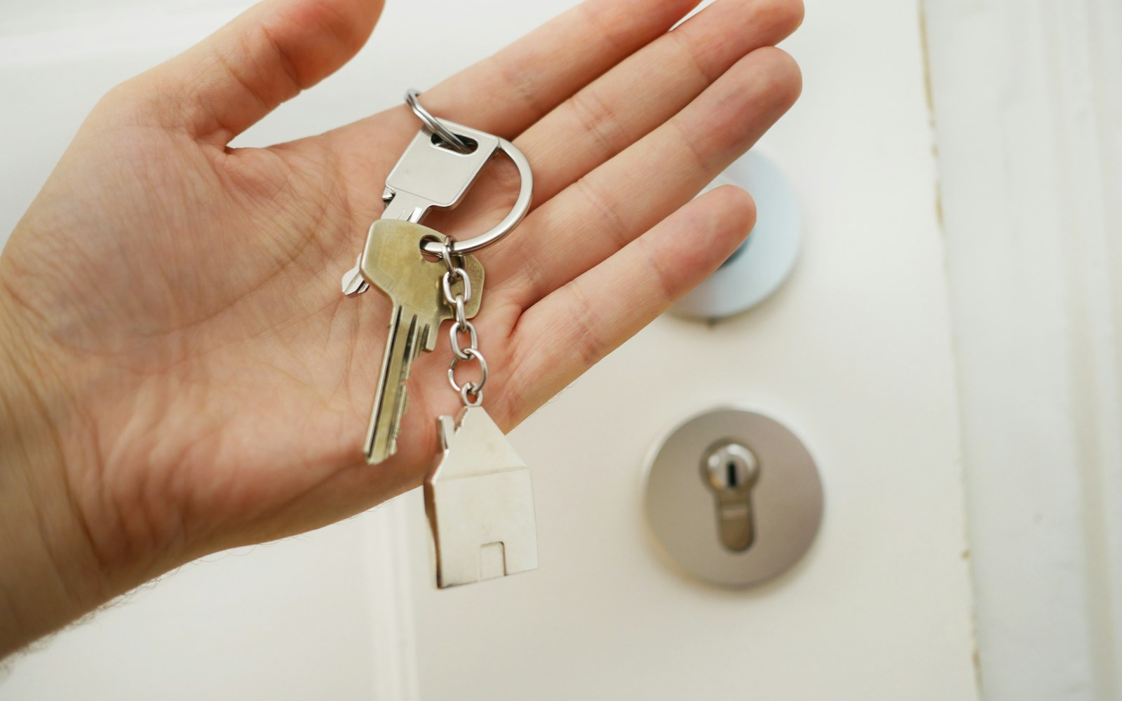House keys held at a front door after a completed transaction