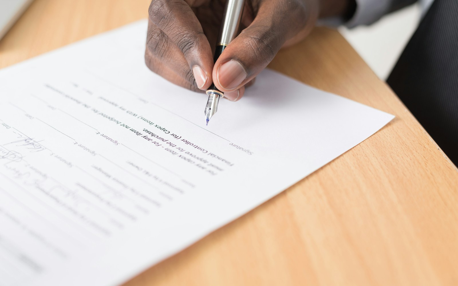 Buyer documents being reviewed and signed at a desk
